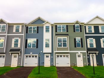 Exterior of Terraces at Shepherdstown townhomes with white garage doors